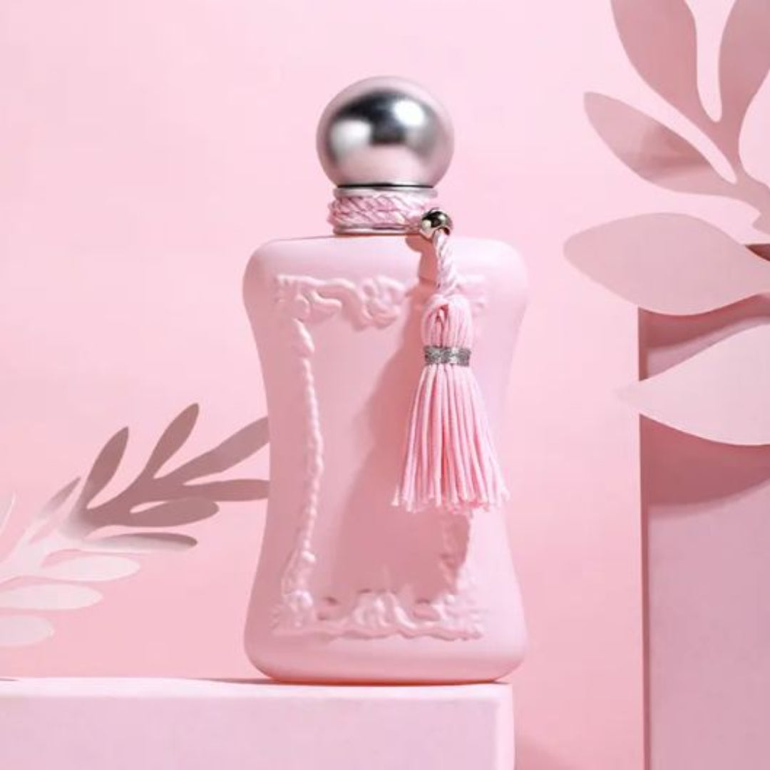 Pink perfume bottle with silver cap and tassel on a pink background
