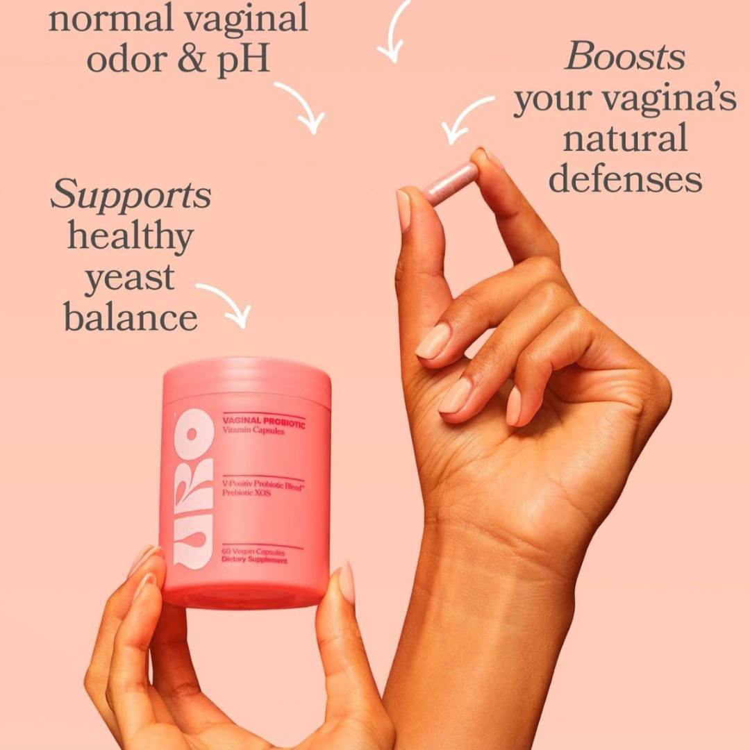 Hand holding a pink container with text about vaginal health on a pink background
