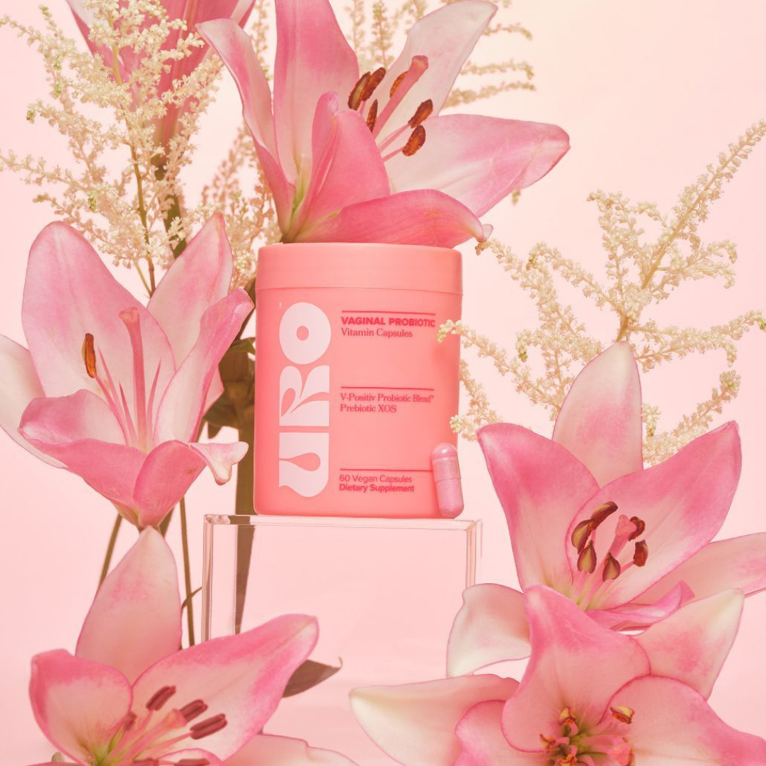 Pink container with a logo surrounded by pink flowers on a pink background